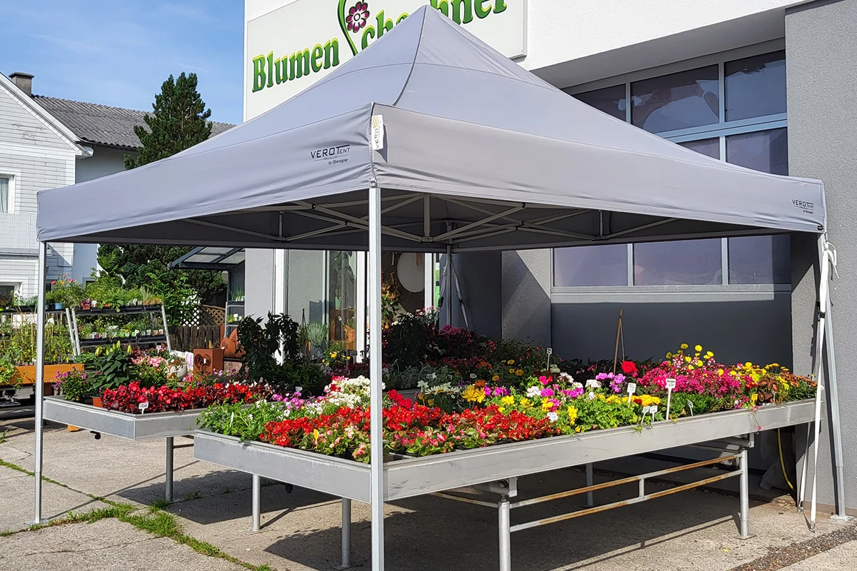 Bedrucktes Faltzelt 4x4 m als Verkaufszelt vor einem Blumengeschäft – graues Dach mit Logo auf der Dachblende