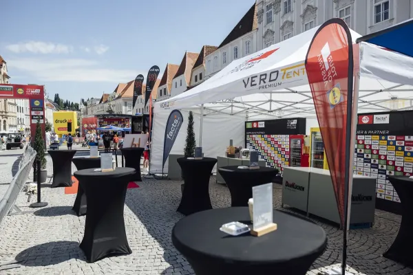 Faltzelt 4x8 als Messezelt und Hospitality-Bereich der Tour of Austria am Stadtplatz &ndash; Stehtische, Beachflags, Partnerwand
