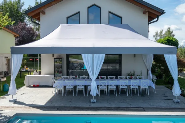 Faltzelt 4x8 als Partyzelt bei einer Gartenfeier am Pool &ndash; wei&szlig;e Tafel mit Ziervorh&auml;ngen
