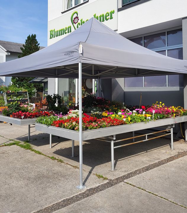 Bedrucktes Faltzelt 4x4 m als Verkaufszelt vor einem Blumengeschäft – graues Dach mit Logo auf der Dachblende